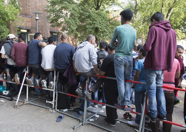 Refugees from Syria wait behind barriers in the central reception centre for asylum seekers at the State Office for Health and Social Affairs in Berlin, 26/08/2015