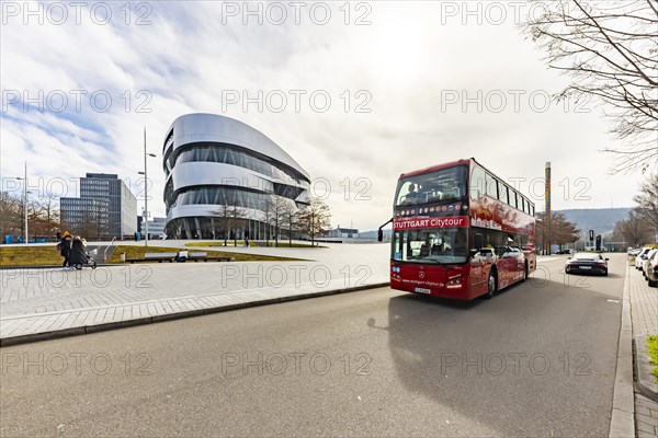 Stuttgrt Citytour. City tour in a red double-decker. City view of Stuttgart in front of the Mercedes-Benz Museum and the Mercedes Benz World in Bad Cannstatt, Stuttgart, Baden-Wuerttemberg, Germany, Europe