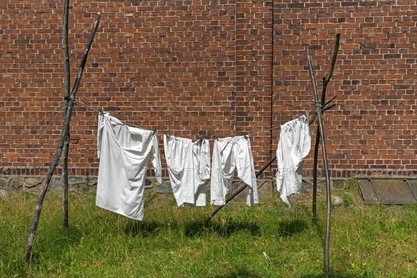 Laundry on the line in front of a 19th century brick farmhouse, Open Air Museum of Folklore Schwerin-Muess, Mecklenburg-Vorpommerm, Germany, Europe