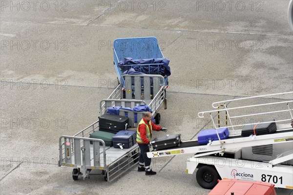 Ground staff loading luggage onto the conveyor belt of an aircraft, Hamburg, Hanseatic City of Hamburg, Germany, Europe