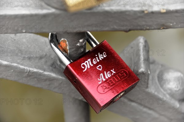 A red love lock with engraved names attached to a metal railing, Hamburg, Hanseatic City of Hamburg, Germany, Europe