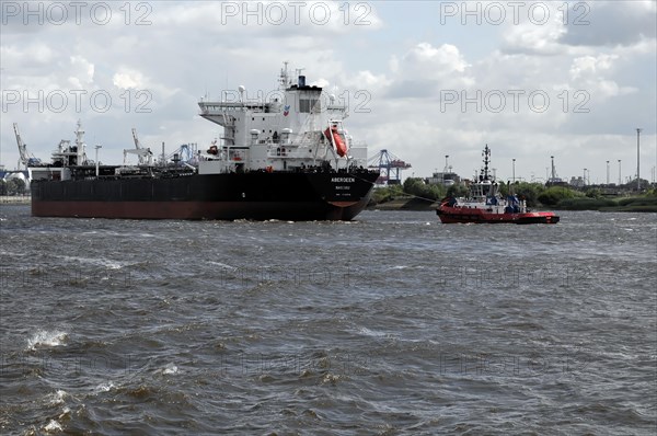 A tanker and a tugboat in the turbulent waters of a harbour, Hamburg, Hanseatic City of Hamburg, Germany, Europe