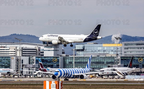 A Lufthansa Airbus A320-200 with the name of the city of Norderstedt on approach to Frankfurt Airport, with Eurowings, Air Canada and Condor aircraft on the ground 15/03/2024