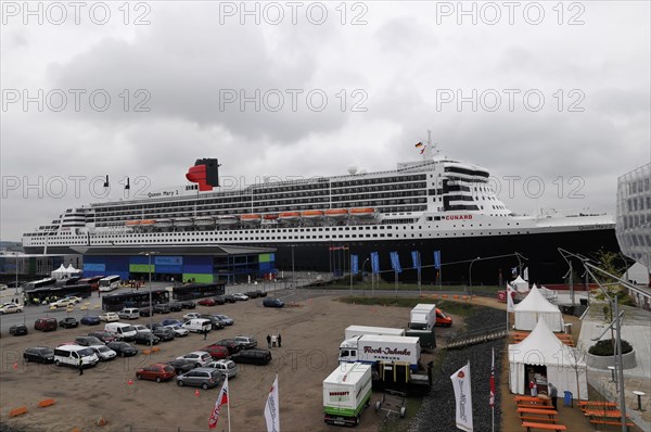 Large cruise ship Queen Mary 2, at a harbour with parked vehicles and people, Hamburg, Hanseatic City of Hamburg, Germany, Europe