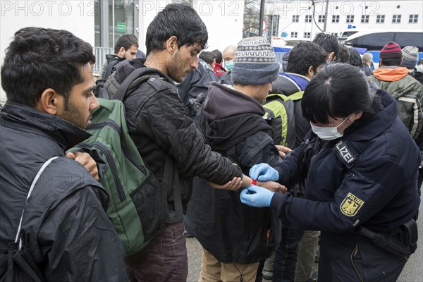 After arriving at Rosenheim station, refugees are given wristbands by federal police officers for identification and registration, 05/02/2016