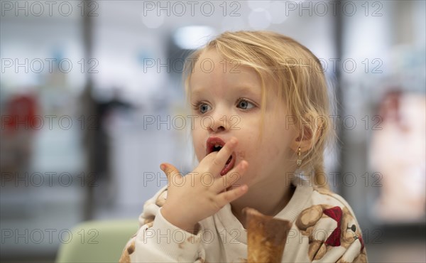 Interior shot, girl, 2-3 years, blonde, eating chocolate ice cream, ice cream, waffle, mouth smeared, logo pharmacy, Stuttgart, Baden-Wuerttemberg, Germany, Europe
