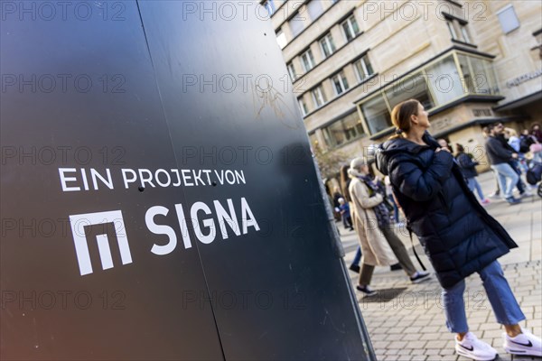 Construction fence in Stuttgart city centre with the Signa Real Estate logo. Rene Benko's property company was planning a commercial building for retail, restaurants and offices on the corner of Koenigstrasse and Schulstrasse. However, the insolvency of the Galeria Karstadt Kaufhof department stores' chain has left the future of the prime property open. Stuttgart, Baden-Wuerttemberg, Germany, Europe