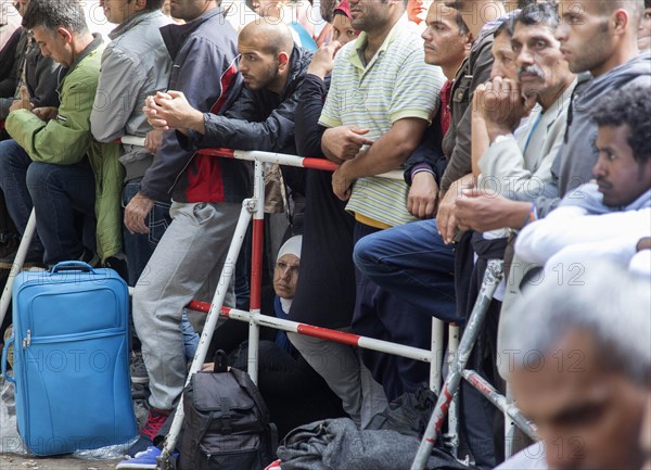 Refugees from Syria wait behind barriers in the central reception centre for asylum seekers at the State Office for Health and Social Affairs in Berlin, 26/08/2015