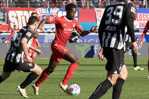 Football match, Omar TRAORE 1.FC Heidenheim in the centre on the ball, Joe SCALLY Borussia Moenchengladbach on the left, football stadium Voith-Arena, Heidenheim