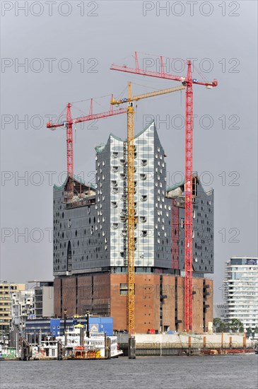 Elbe Philharmonic Hall under construction with cranes and grey sky in the background in Hamburg, Hamburg, Hanseatic City of Hamburg, Germany, Europe