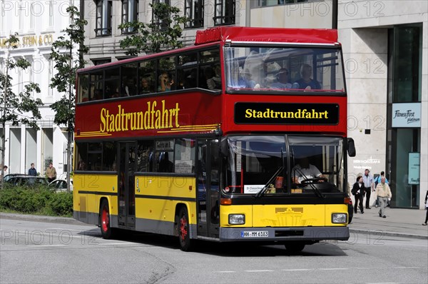 A red double-decker bus for city tours drives through a sunny city street, Hamburg, Hanseatic City of Hamburg, Germany, Europe