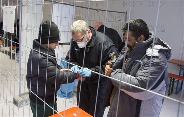 Refugees are searched by federal police officers after their arrival at Rosenheim station, 05/02/2016