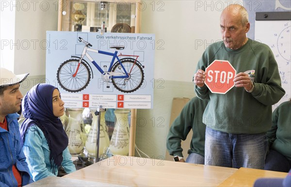 Syrian refugees learn traffic rules during an integration course. An employee of the Oberspreewald-Lausitz district and traffic watch organisation shows and explains traffic signs and rules to the refugees in the rooms of the Grossraeschen sports club, 05/10/2016