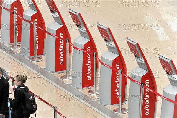 Travellers waiting at a row of self-service check-in machines at the airport, Hamburg, Hanseatic City of Hamburg, Germany, Europe