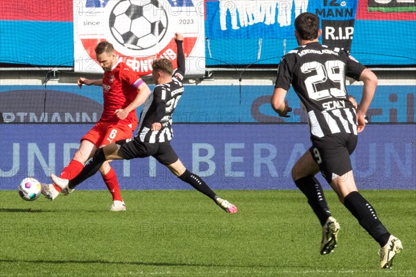 Football match, captain Patrick MAINKA 1.FC Heidenheim left in a duel with Robin HACK Borussia Moenchengladbach, Joe SCALLY Borussia Moenchengladbach right observes the situation, football stadium Voith-Arena, Heidenheim