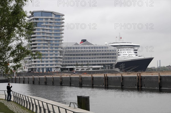 Cruise ship Queen Mary 2, at the dock with modern building in the background under an overcast sky, Hamburg, Hanseatic City of Hamburg, Germany, Europe