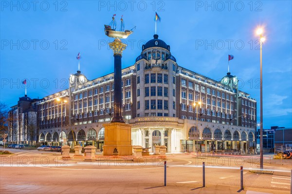 Stoertebeker House at the Blue Hour with granite column and ship, which is a replica of Stoertebeker's cog, Hamburg, Germany, Europe