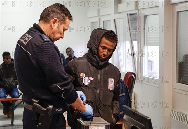 Refugees are registered and recorded by the Federal Police in Rosenheim. A Federal Police officer takes a fingerprint scan, 05/02/2016