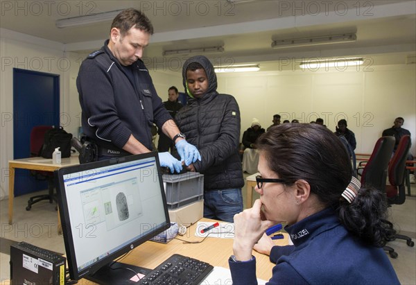 Refugees are registered and recorded by the Federal Police in Rosenheim. A Federal Police officer takes a fingerprint scan, 05/02/2016