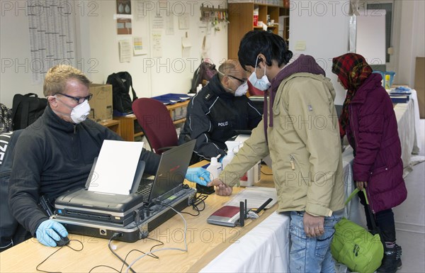 Refugees are registered and recorded by the Federal Police in Rosenheim. A Federal Police officer takes a fingerprint scan, 05.02.16