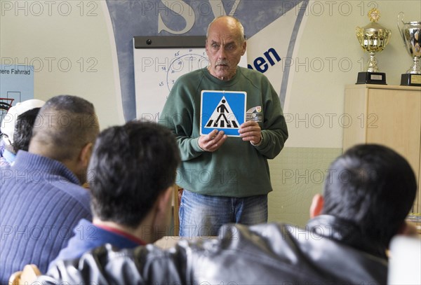 Syrian refugees learn traffic rules during an integration course. An employee of the Oberspreewald-Lausitz district and traffic watch organisation shows and explains traffic signs and rules to the refugees in the rooms of the Grossraeschen sports club, 05/10/2016
