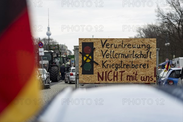 A demonstration sign mounted on a car trailer, vehicles blocking Strasse des 17. Juni, the Berlin TV tower in the background, taken as part of the 'AeoeFarmers' protests'Aeo in Berlin, 22/03/2024