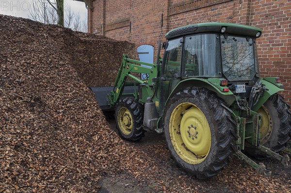 Tractor loading woodchippings on a farm, Othenstorf, Mecklenburg-Vorpommern, Germany, Europe