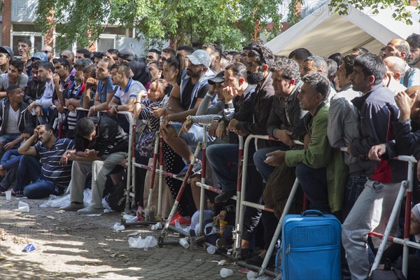 Refugees from Syria wait behind barriers in the central reception centre for asylum seekers at the State Office for Health and Social Affairs in Berlin, 26/08/2015