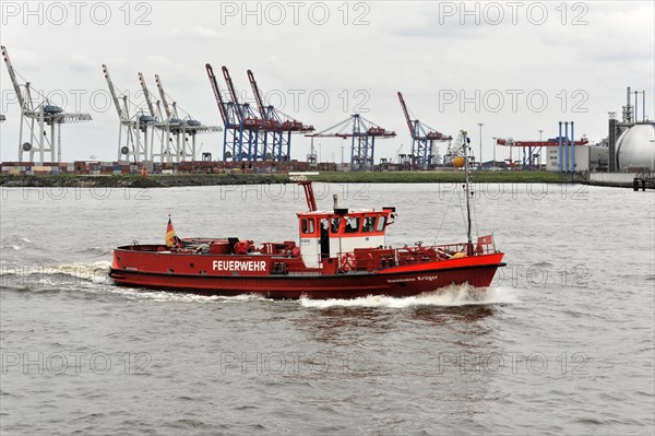 A red fire boat sailing through the water in Hamburg harbour, Hamburg, Hanseatic City of Hamburg, Germany, Europe