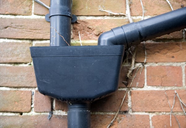 Plastic drainpipes on red brick wall