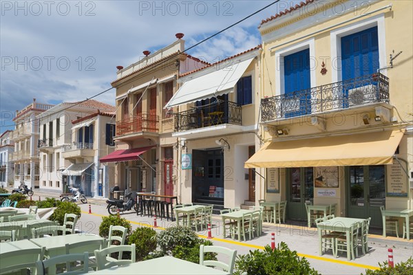 Mediterranean street with colourful buildings, an outdoor restaurant and a clear blue sky, promenade, Poros, Poros Island, Saronic Islands, Peloponnese, Greece, Europe