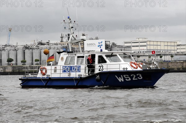 Police boat on the water with crew and cloudy sky in the background, Hamburg, Hanseatic City of Hamburg, Germany, Europe
