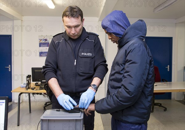 Refugees are registered and recorded by the Federal Police in Rosenheim. A Federal Police officer takes a fingerprint scan, 05.02.16