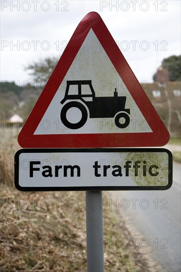 Red triangular road sign for farm traffic, UK