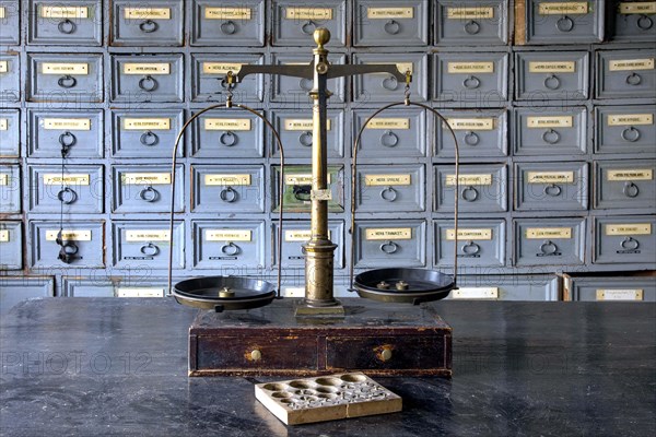A pharmacist's scales stand on a worktable in front of shelves with drawers containing ingredients for the production of medicines in the former laboratory of the historic Berg Pharmacy in Clausthal-Zellerfeld. The current Berg-Apotheke, one of the oldest pharmacies in Germany, was built in 1674, 09.11.2015