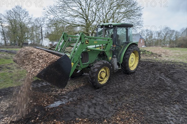 Tractor loading woodchippings on a farm, Othenstorf, Mecklenburg-Vorpommern, Germany, Europe