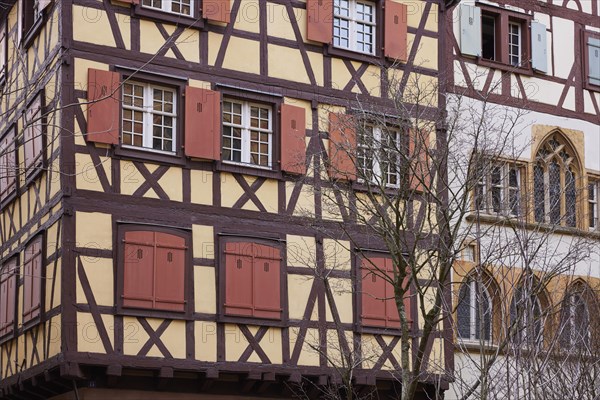 Pastel orange facade of a half-timbered house with windows and red shutters in the historic centre of Colmar, Department Haut-Rhin, Grand Est, France, Europe
