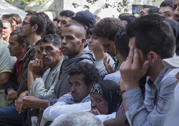 Refugees from Syria wait behind barriers in the central reception centre for asylum seekers at the State Office for Health and Social Affairs in Berlin, 26/08/2015