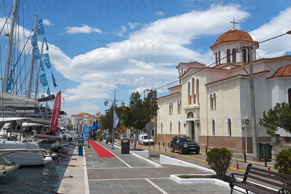 A picturesque harbour view with a church, yachts and a promenade under a blue sky, Promenade, Holy Church of the Annunciation of the Theotokos, Poros, Poros Island, Saronic Islands, Peloponnese, Greece, Europe