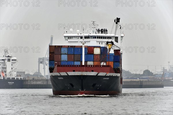 A large container ship loaded with colourful containers sails through the port, Hamburg, Hanseatic City of Hamburg, Germany, Europe