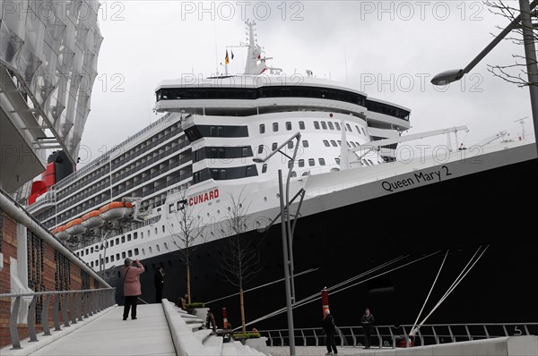 A large cruise ship Queen Mary 2, at the dock, people walking on the jetty, Hamburg, Hanseatic City of Hamburg, Germany, Europe
