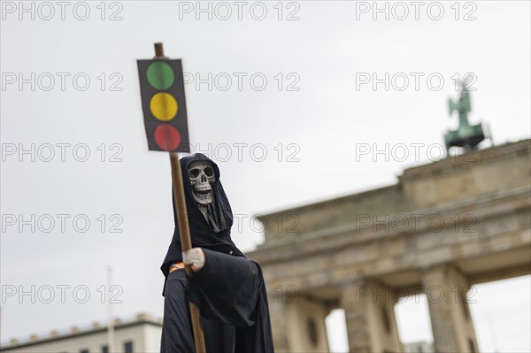 The figure of a grim reaper (skeleton) with a traffic light as a sign, the Brandenburg Gate in the background, taken as part of the 'AeoeFarmers' protests'Aeo in Berlin, 22 March 2024