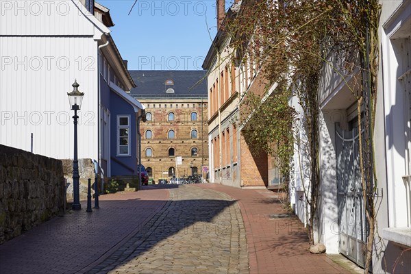 Alley Martinikirchhof with cobblestones and lantern in the city centre of Minden, Muehlenkreis Minden-Luebbecke, North Rhine-Westphalia, Germany, Europe