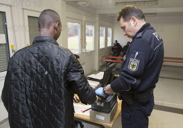 Refugees are registered and recorded by the Federal Police in Rosenheim. A Federal Police officer takes a fingerprint scan, 05/02/2016