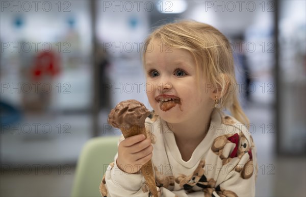 Interior shot, girl, 2-3 years, blonde, eating chocolate ice cream, ice cream, waffle, mouth smeared, smiling, cheerful, logo, pharmacy, Stuttgart, Baden-Wuerttemberg, Germany, Europe