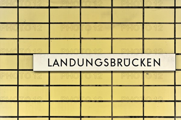 A sign with the inscription 'Landungsbruecken' on a yellow tiled wall, Hamburg, Hanseatic City of Hamburg, Germany, Europe