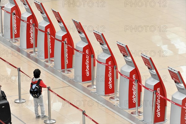 A child standing in front of self-service check-in machines in an airport queue, Hamburg, Hanseatic City of Hamburg, Germany, Europe