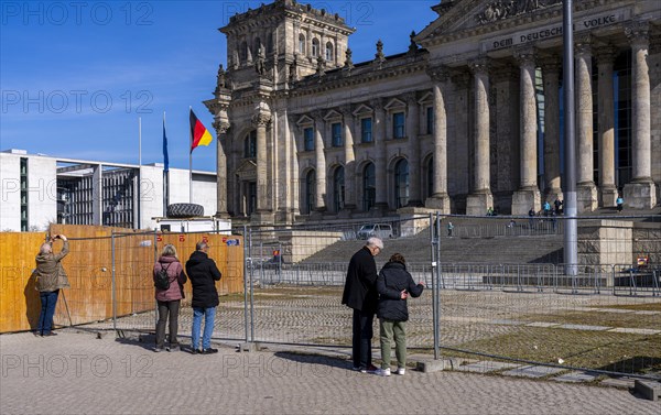Tourists standing at the construction fence in front of the Reichstag building, Berlin, Germany, Europe