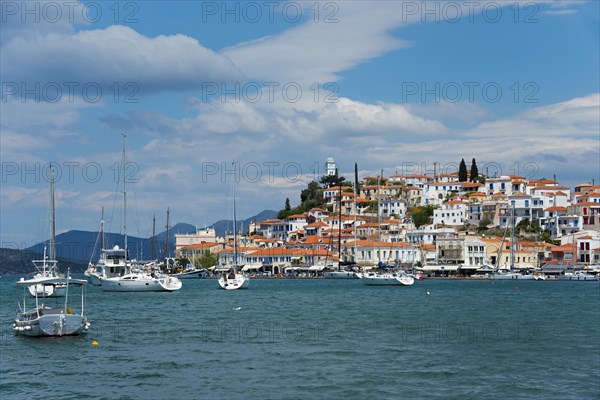 View of an idyllic coastal town with white houses and sailing boats on clear blue water, view from Galatas, Argolis, to Poros, Poros Island, Saronic Islands, Peloponnese, Greece, Europe