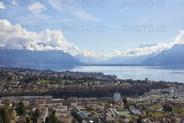 View of Vevey and Lake Geneva with cloudy, misty mountains in the background from Jongny, Riviera-Pays-d'Enhaut district, Vaud, Switzerland, Europe